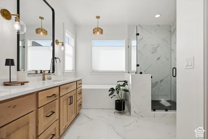 Dual-sink vanity with wood-finish cabinetry, white countertop, and gold-tone fixtures