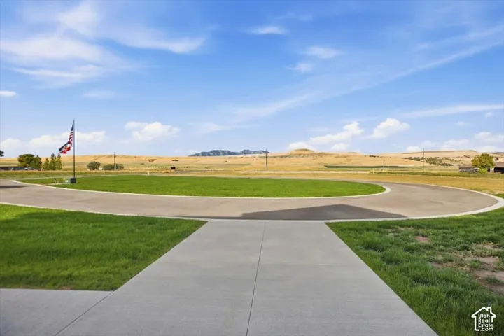 Paved circular driveway with a central grassy median and surrounding natural landscape