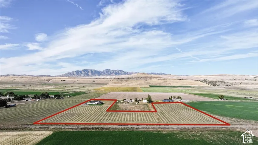 Expansive agricultural property featuring cultivated fields and multiple outbuildings