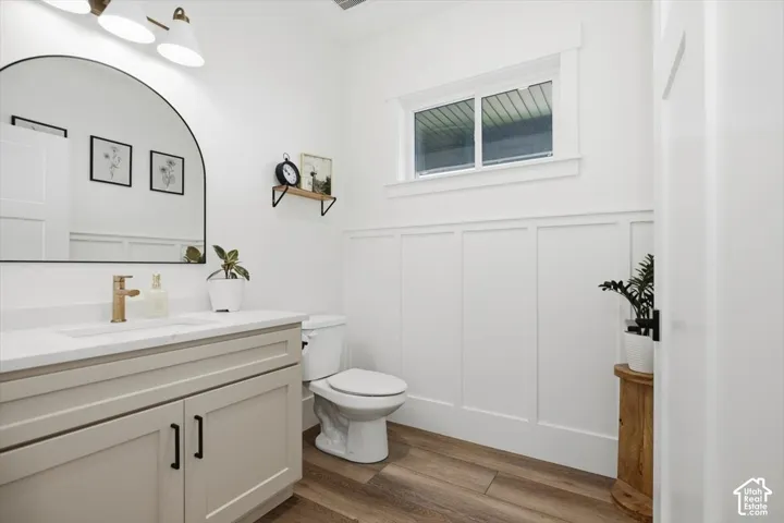 White vanity with a single basin, gold-finish faucet, and coordinating hardware