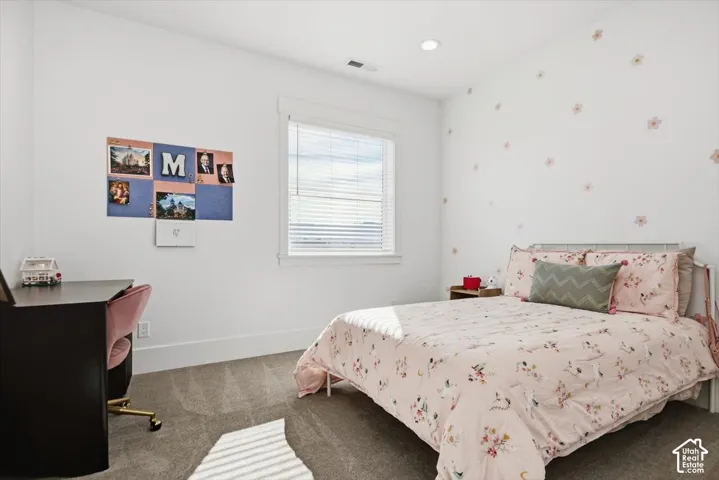 Plush carpeting, recessed lighting, and a window with horizontal blinds