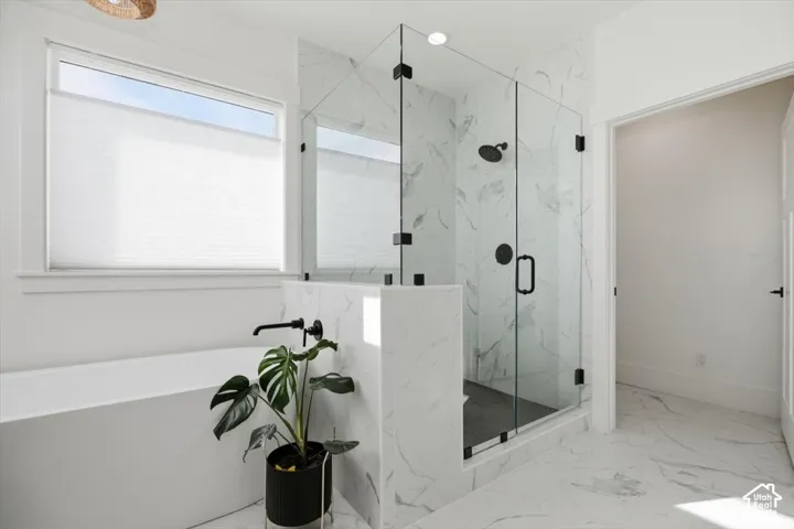 Freestanding soaking tub with a wall-mounted matte black faucet