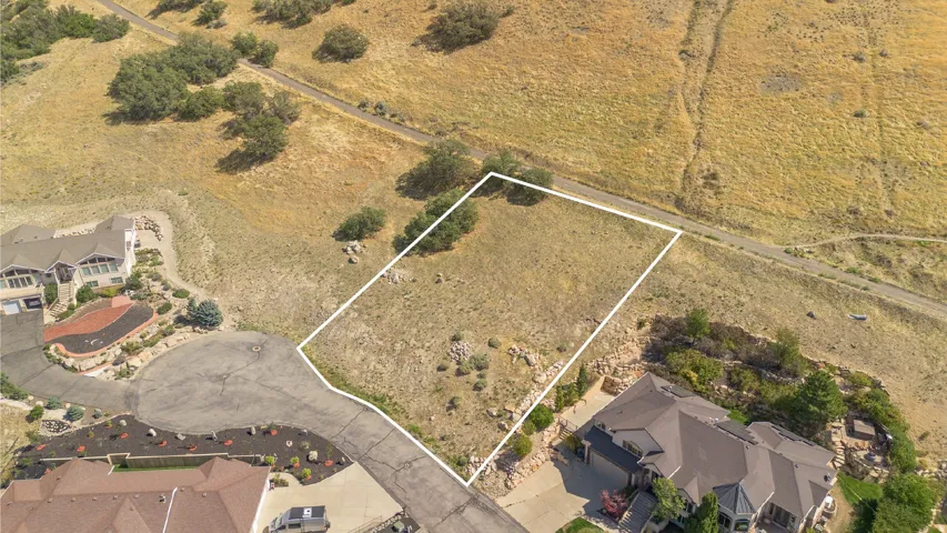 Gradual sloping terrain with natural vegetation, bordered by developed residential properties