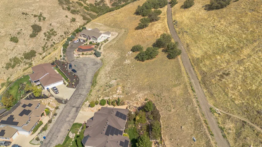 Cul-de-sac location with a paved driveway, surrounding natural landscape, and mature trees