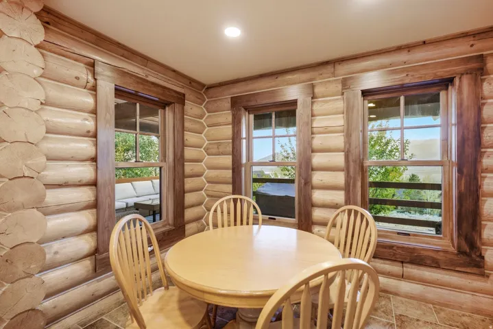 Log wall construction, wood-trimmed windows, recessed lighting, and tile flooring