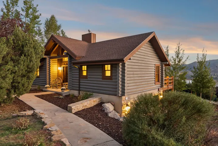 Log siding exterior with a pitched roof and visible structural beams at the entrance