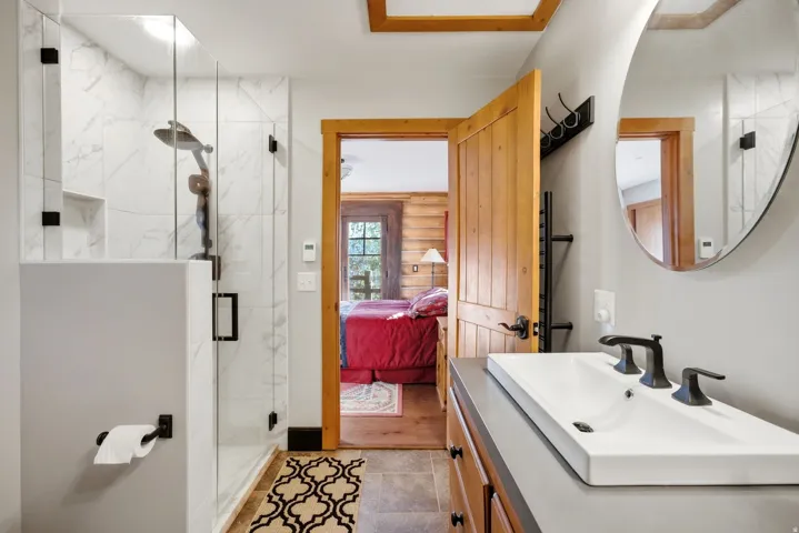 Walk-in shower with clear glass enclosure and large format tile surround