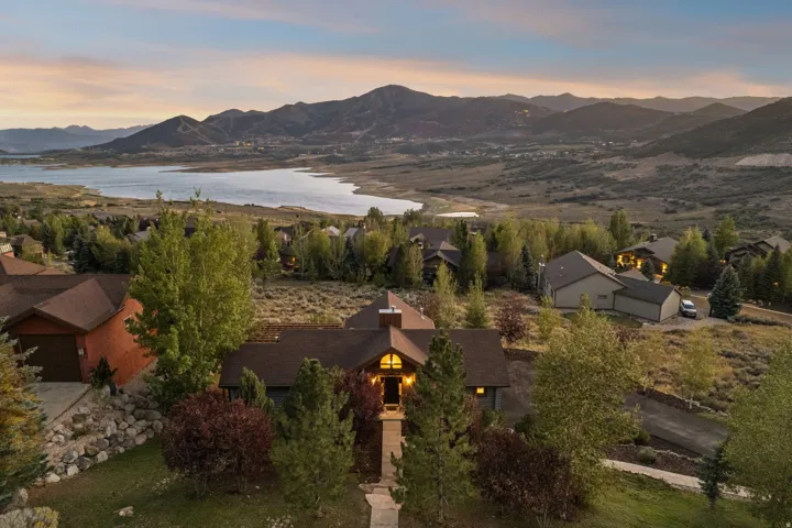 Property featuring a stone pathway entrance, mature landscaping, and a multi-pitch roofline