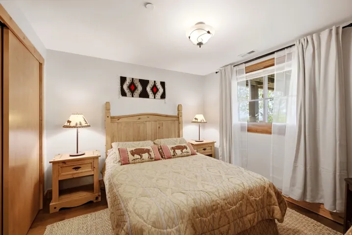 Hardwood flooring, light wood-finish built-in closet, wood-frame window, and a ceiling-mounted light fixture