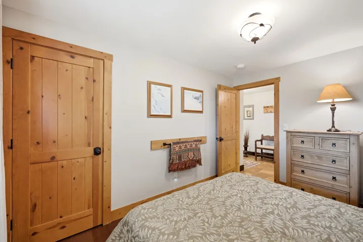 Knotty pine interior doors and trim with black hardware, white walls, and wood-finish flooring
