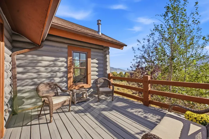 Expansive outdoor deck with a wood railing, offering broad distant scenery