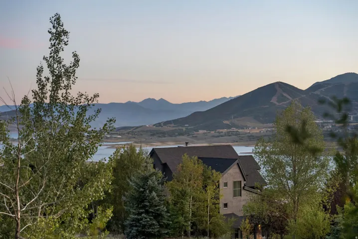 Mature trees surrounding the property with distant mountain and water scenery