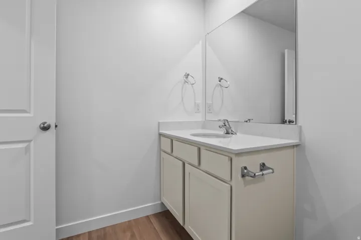Vanity with an integrated sink, polished chrome faucet, and a large wall-mounted mirror