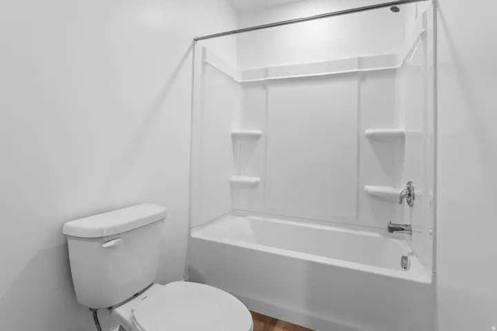 White acrylic tub/shower combination with integrated shelving and chrome fixtures