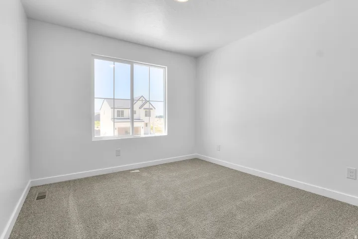 Neutral wall finishes, plush carpeting, modern window, and overhead lighting