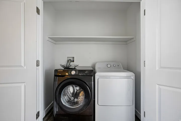 Built-in laundry closet with a single storage shelf and double panel doors