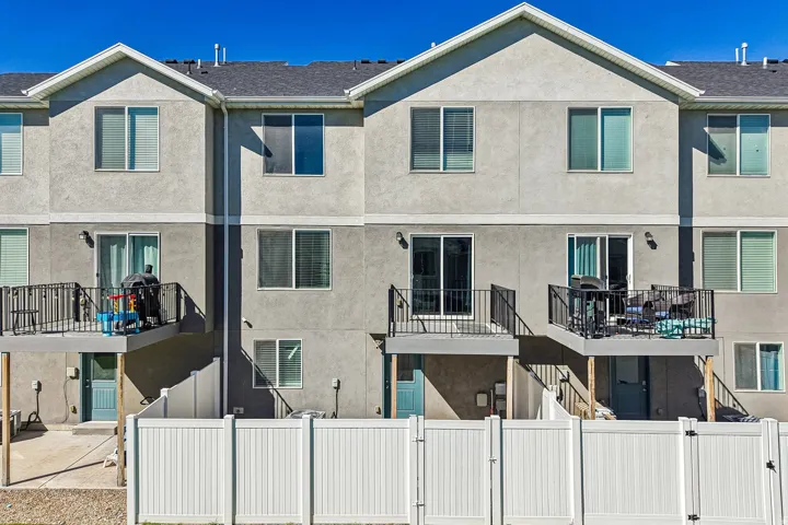 Stucco exterior with multiple balconies featuring black metal railings
