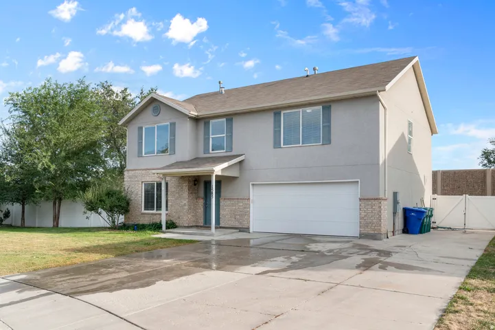 Two-story residence featuring stucco and brick veneer siding, a covered entry, and an attached two-car garage