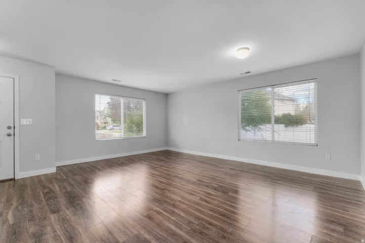 Wood-finish flooring throughout, multiple windows with blinds, and recessed lighting
