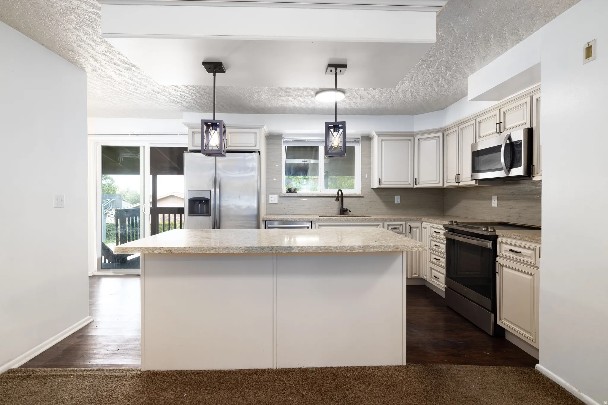 Kitchen featuring a center island, recessed lighting, white cabinetry, dark hardware, and stainless steel appliances