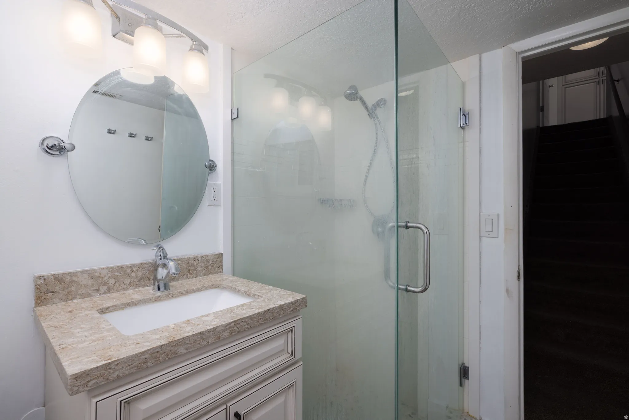Vanity with integrated sink, stone-finish countertop, and white cabinetry