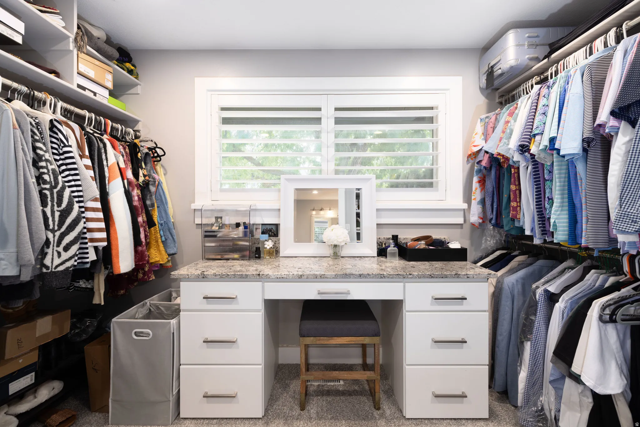 Built-in closet system with shelving, hanging rods, and a window with plantation shutters