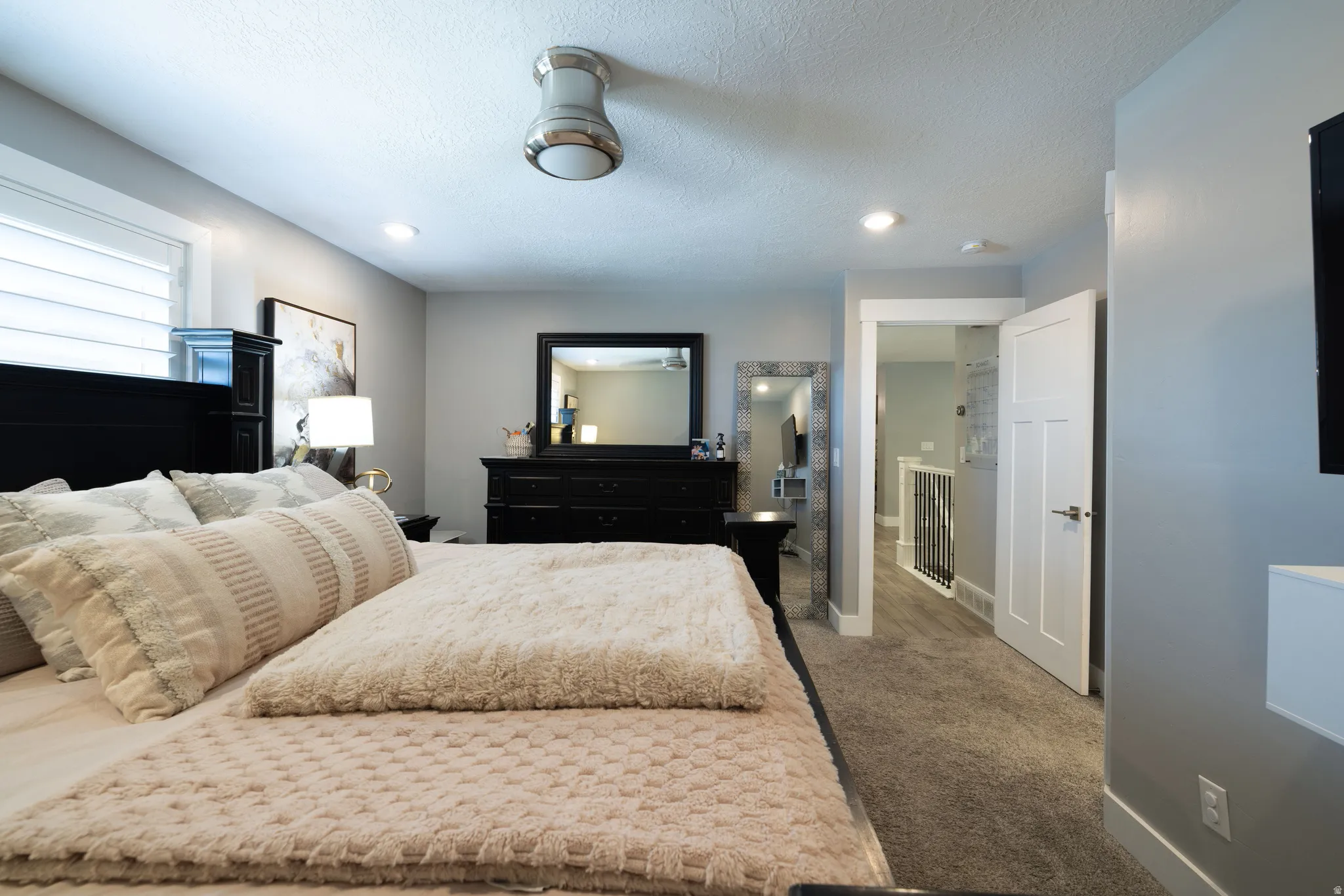Recessed lighting, ceiling-mounted light fixture, paneled interior door, and carpeted flooring