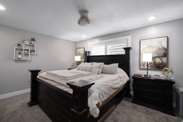 Recessed lighting, ceiling fan, window with plantation shutters, and light gray wall paint