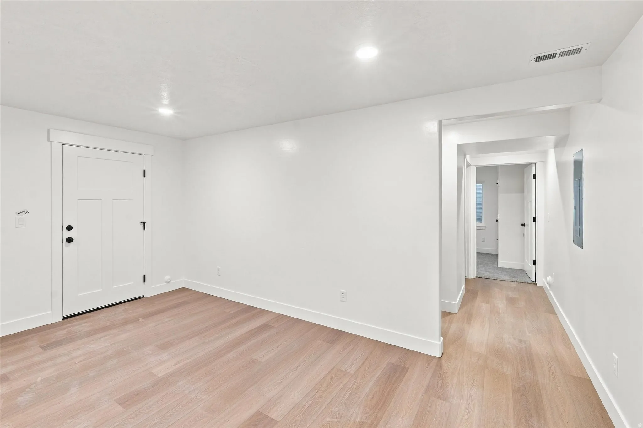 Light wood-finish flooring with white baseboards