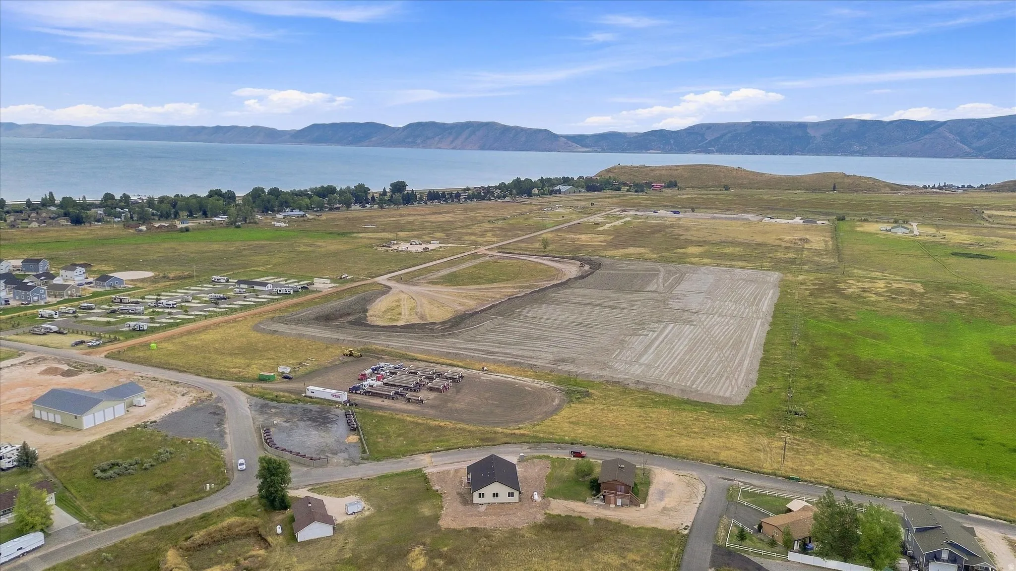 Expansive land parcel featuring partial clearing, surrounding green space, and distant water