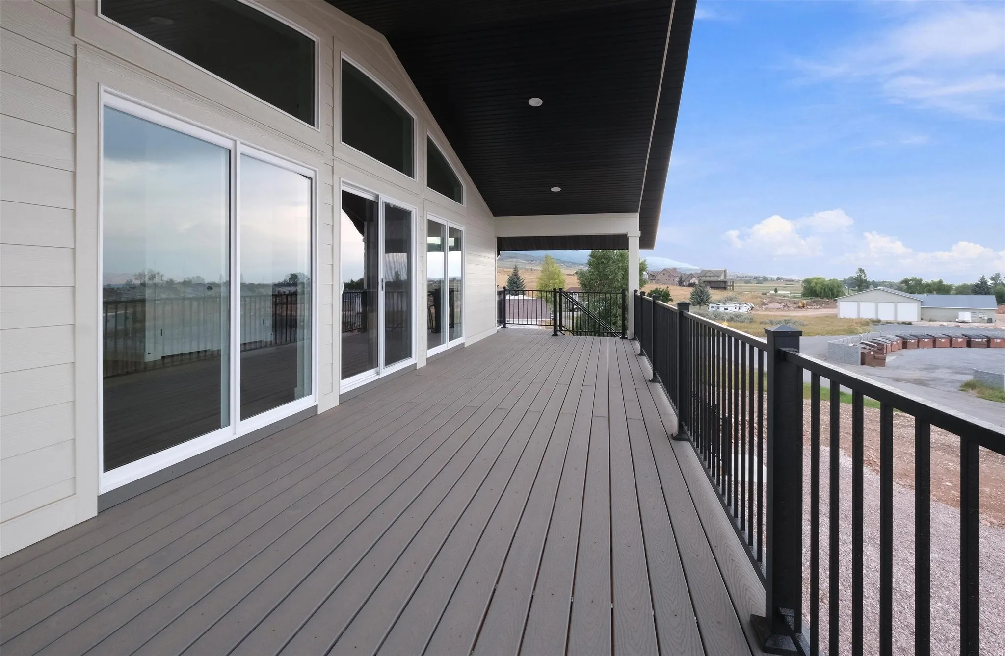 Expansive outdoor deck featuring composite decking and black metal railings