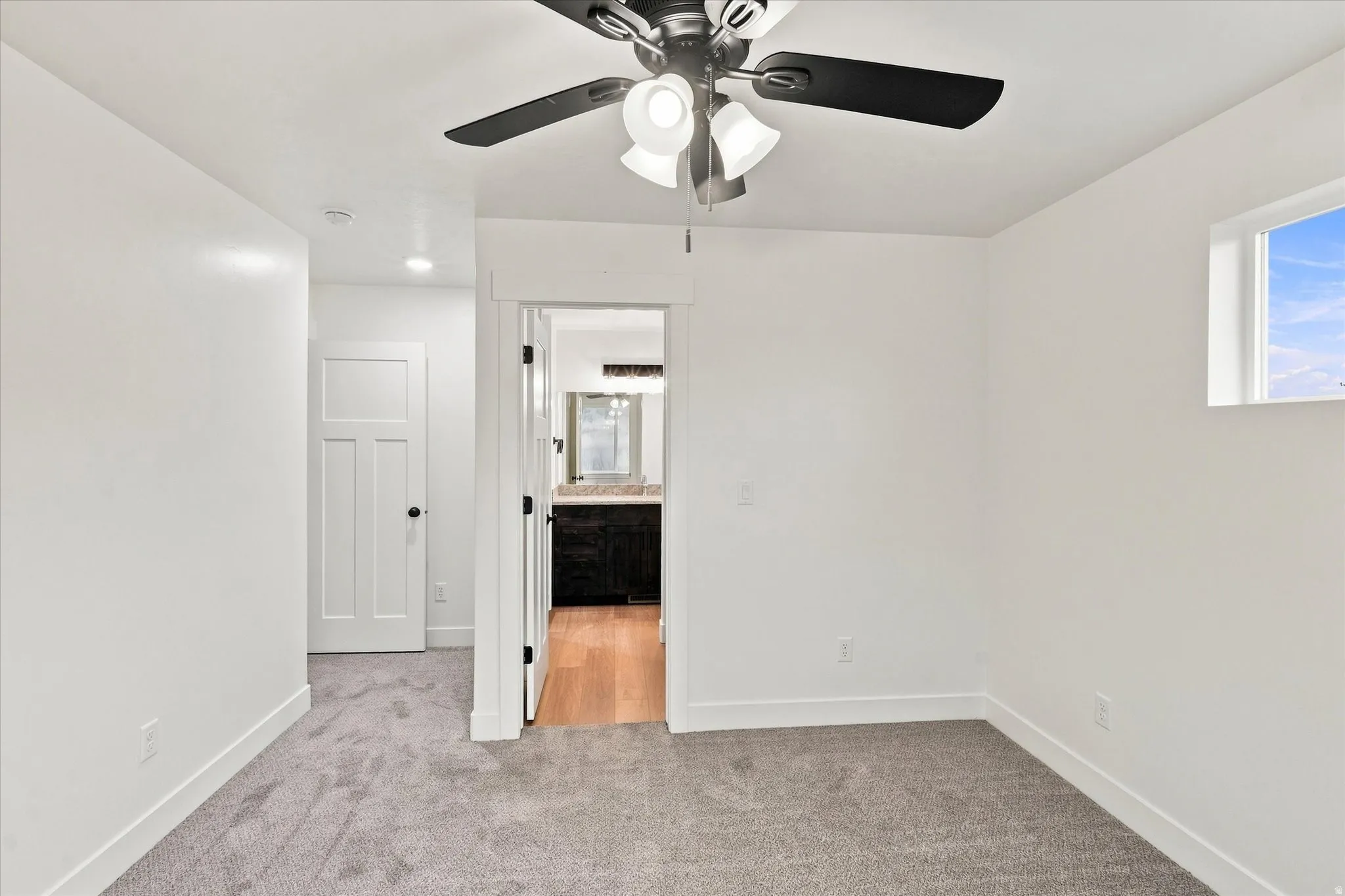 Plush carpeting and a ceiling fan with integrated lighting