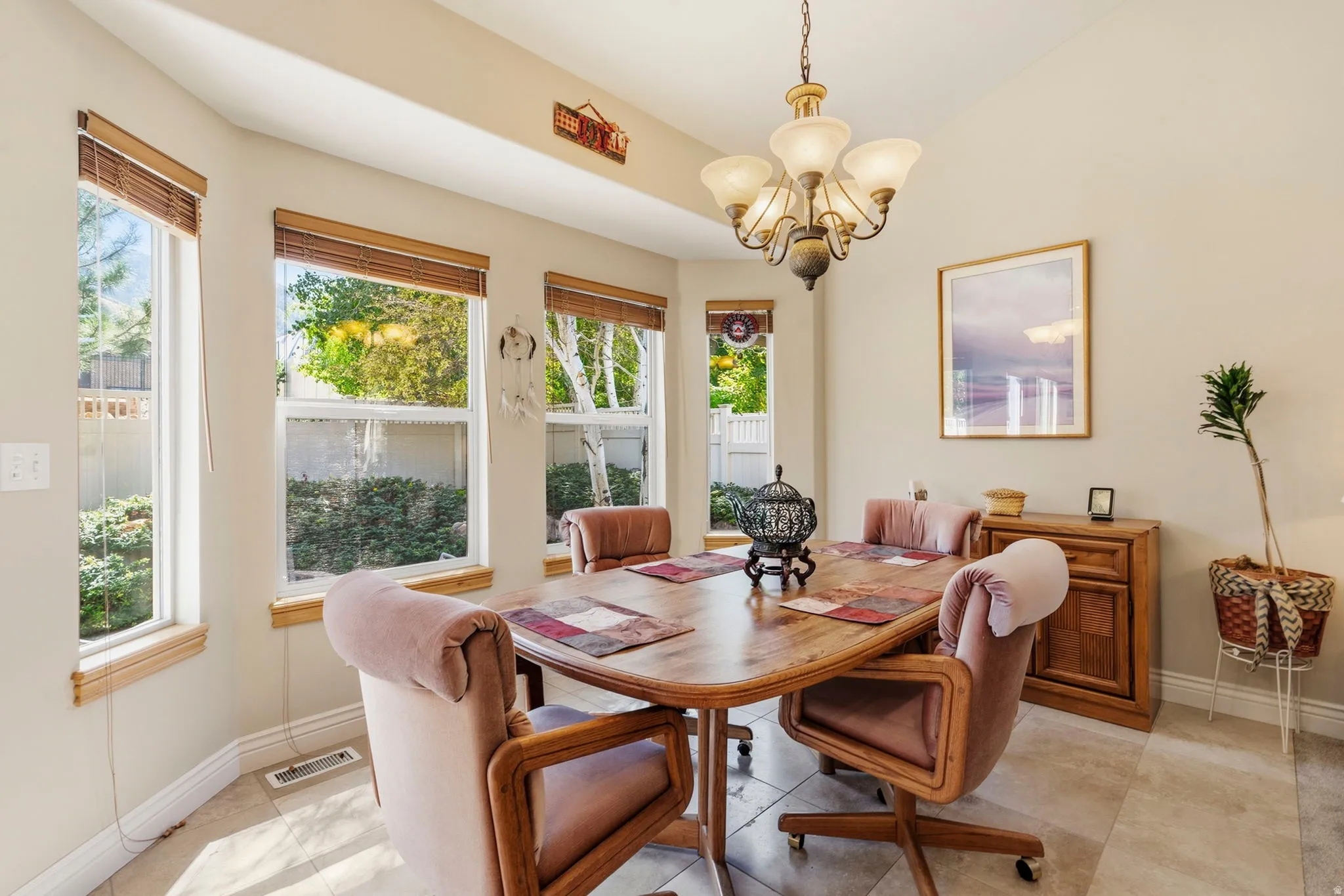 Bay window with multiple large windows, tile flooring, and a decorative chandelier
