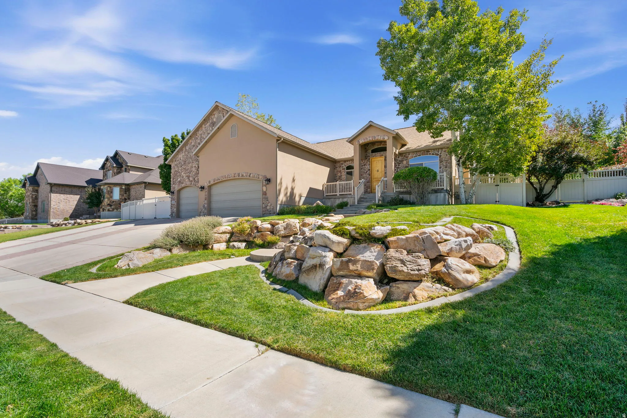 Stucco and stone exterior with an attached two-car garage