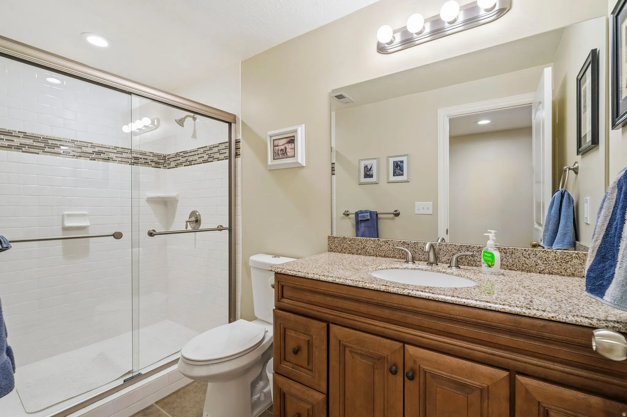 Shower with glass enclosure, subway tile surround, and decorative tile accent