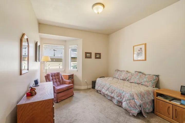 Recessed bay window, neutral carpeting, and a flush mount ceiling light fixture