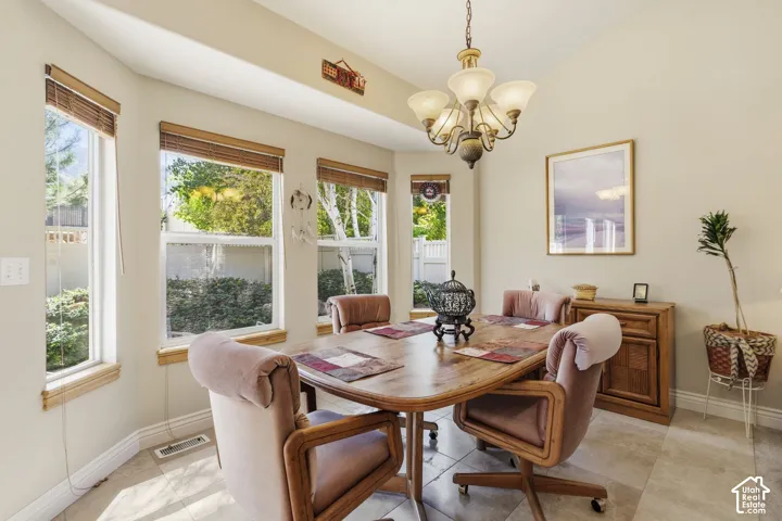 Bay window with multiple large windows, tile flooring, and a decorative chandelier