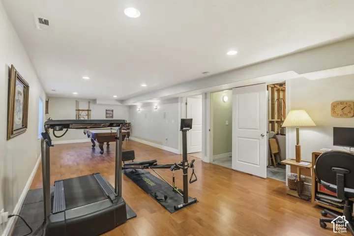 Spacious finished area featuring wood-finish flooring, recessed lighting, and white trim