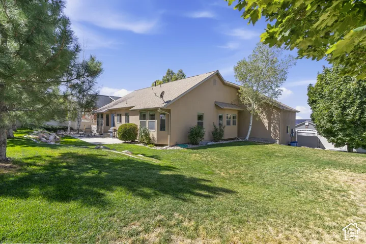 Expansive lawn with mature trees and a paved patio area