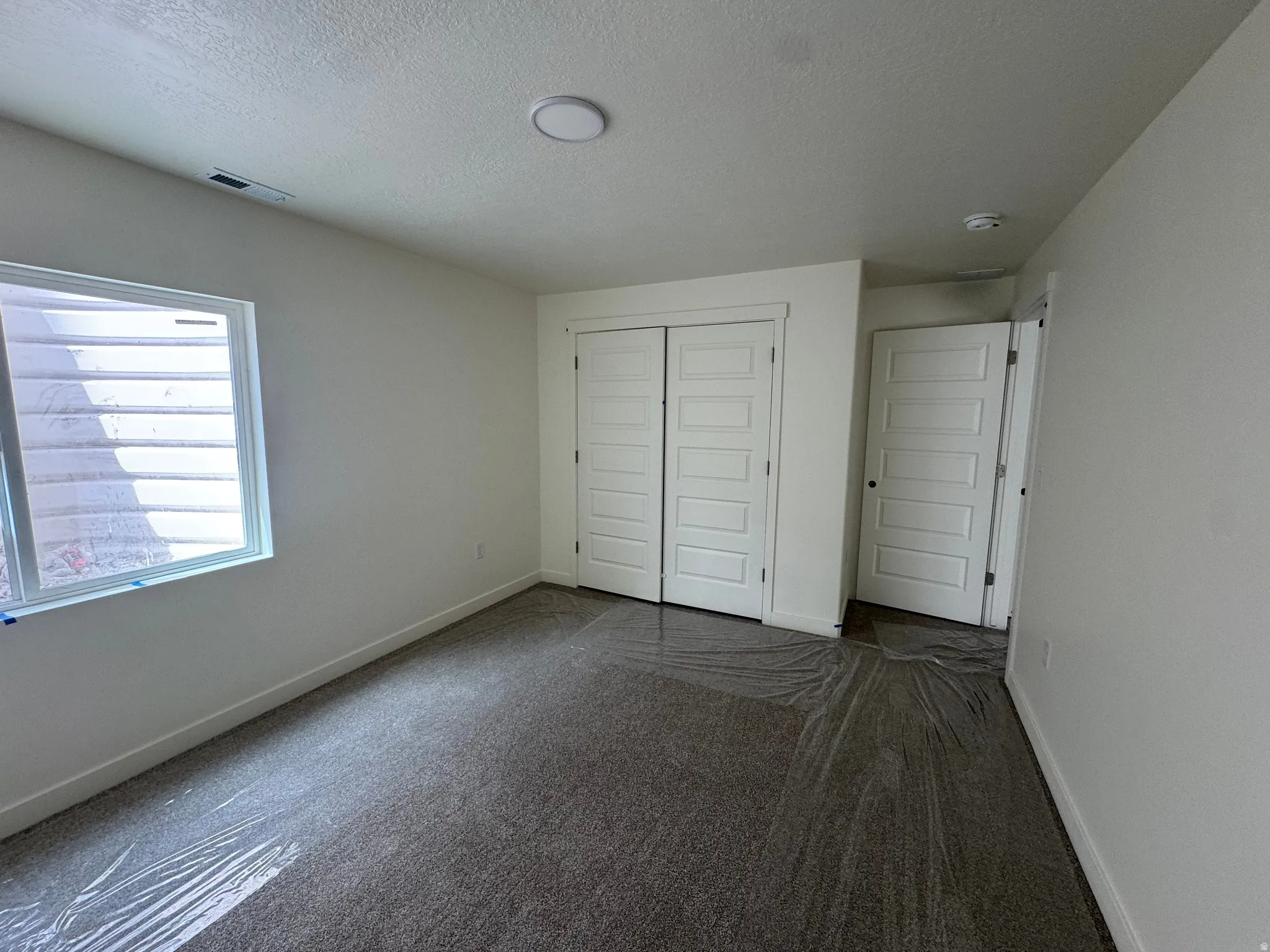 Recessed lighting, window with horizontal blinds, flush mount ceiling fixture, and white paneled doors