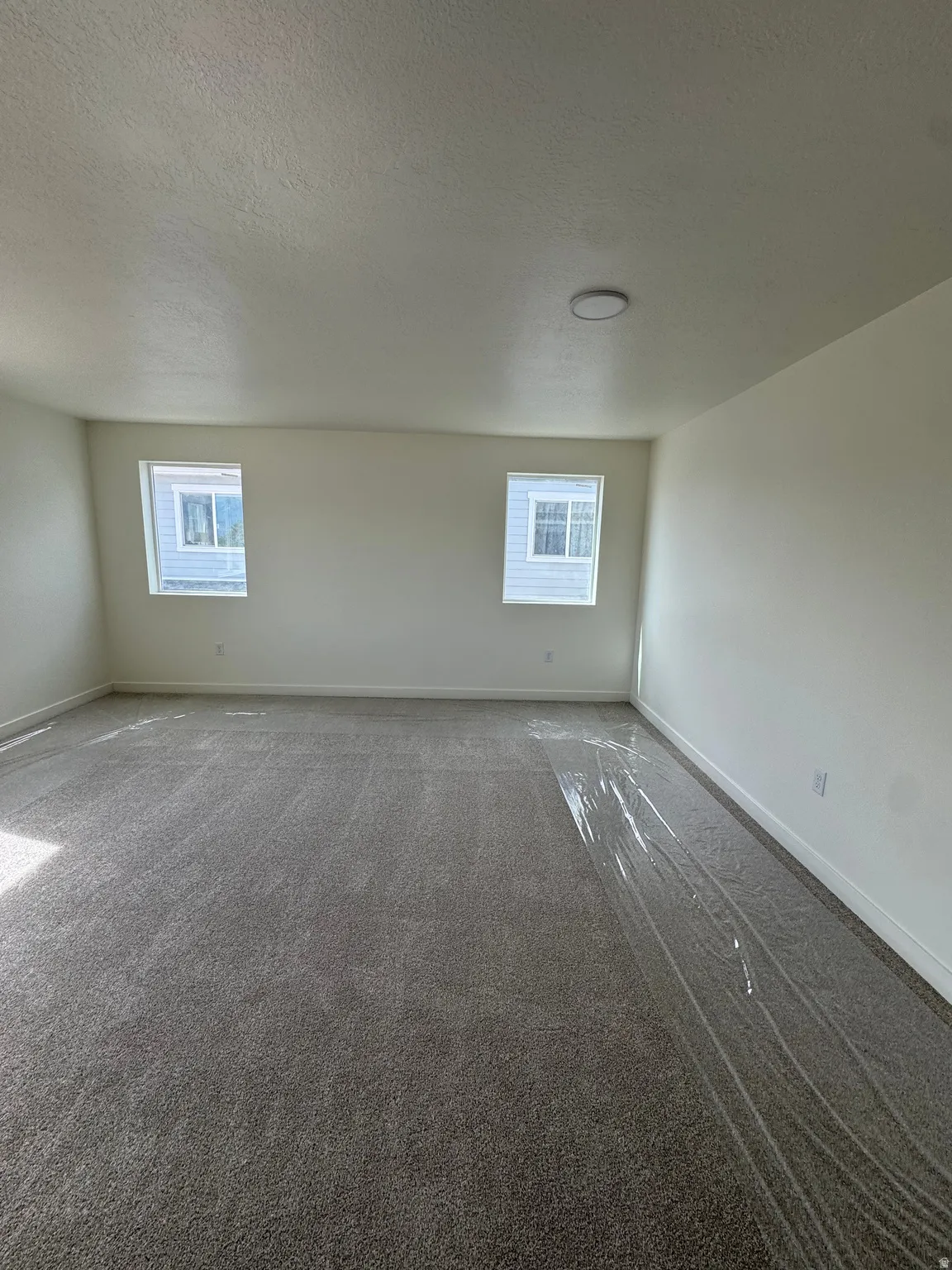 Recessed ceiling lighting, two windows, and gray carpeted flooring