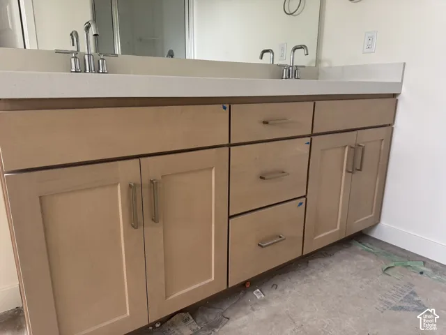 Dual vanity with light wood-finish cabinetry, chrome fixtures, and a light-toned countertop