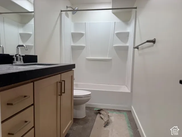 Modern bathroom featuring a wood-finish vanity with dual drawers and brushed brass hardware, black quartz countertop, and chrome faucet
