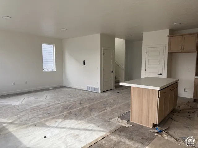 Kitchen island with a light-toned wood finish and a white countertop