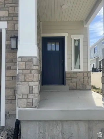 Stone veneer siding, covered entry, and a contrasting blue front door with windowpanes