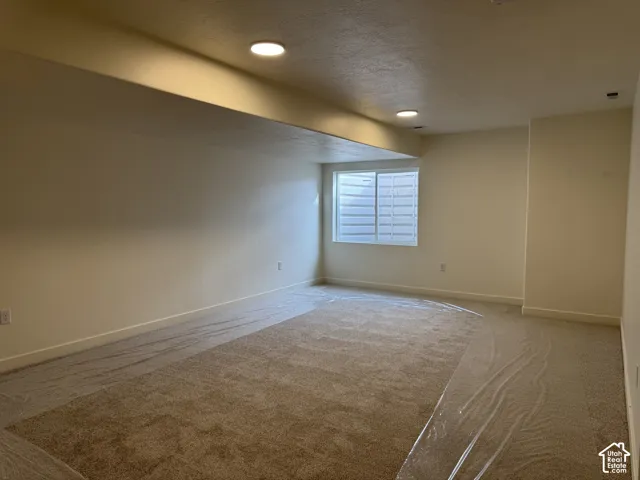 Recessed ceiling lighting, a window with horizontal blinds, and neutral-toned wall paint