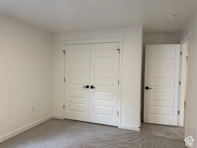 White paneled doors with matte black hardware, light neutral carpet, and white painted walls