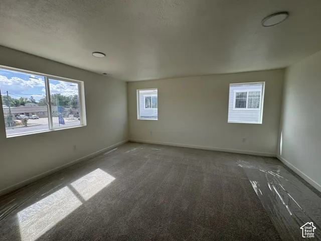 Carpeted room with multiple windows, recessed lighting, and neutral wall finishes
