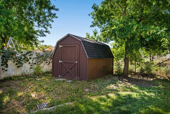 Storage shed with a gambrel roof and a sturdy wood door