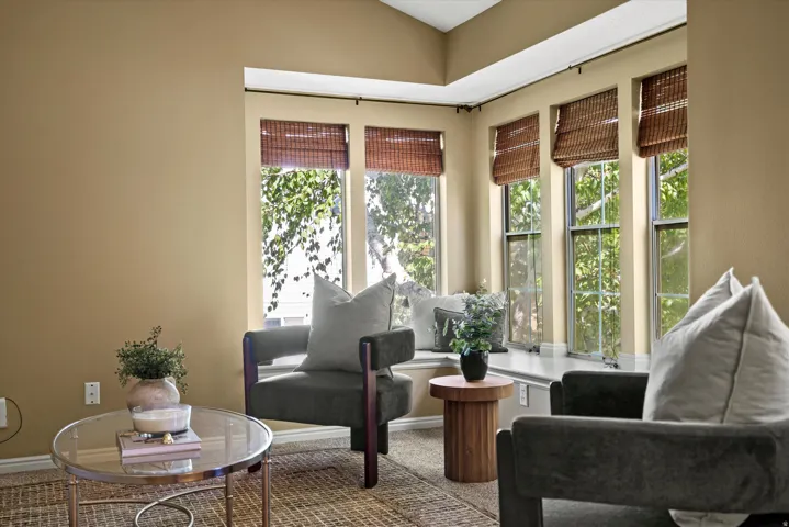 Bay window seating with natural light, vaulted ceilings, and window treatments